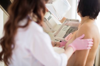 Momologist carrying out the ultrasound examination of the breast of a patient in her office clipart