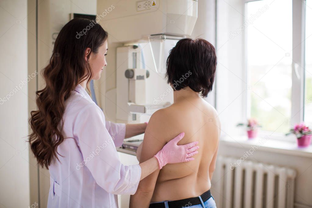 The young breast specialist carrying out the ultrasound examination of the breast of a patient in her office