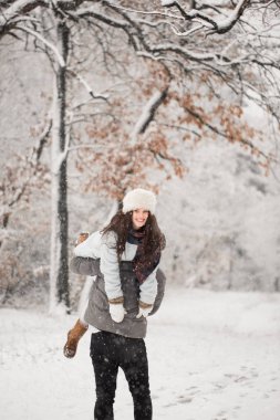 Neşeli kadın bir omuz karla kaplı Park açık havada tutan genç adam