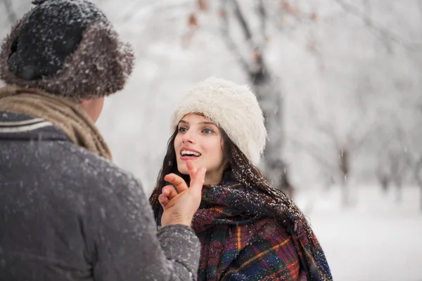 幸福的年轻夫妇站在雪覆盖的公园面对面 — 图库照片