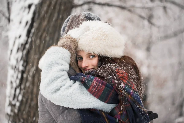 在冰雪覆盖的公园里站在怀抱中的快乐年轻夫妇的侧面视图 — 图库照片
