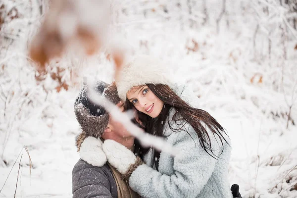 坐在白雪覆盖的公园里 抱着年轻漂亮的女人在膝上的快乐年轻人的肖像 — 图库照片