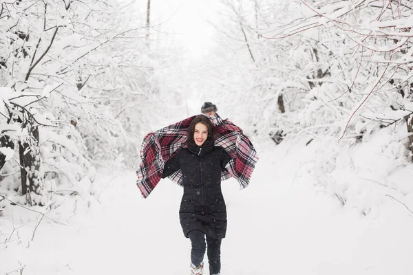 年轻开朗的女人走在雪覆盖的公园里 拿着一条围巾 — 图库照片