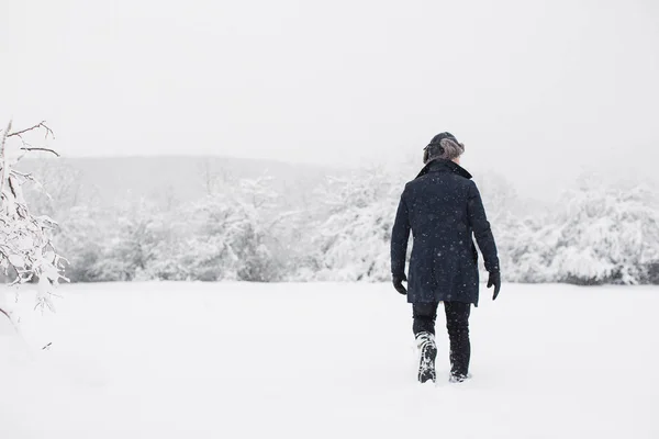 年轻人在雪地里散步 看着一旁 — 图库照片