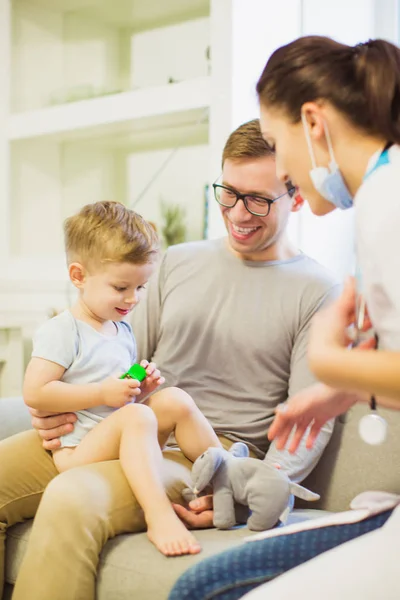 Joven Padre Sonriente Sentado Sofá Habitación Sosteniendo Pequeño Hijo Las — Foto de Stock