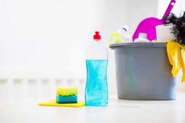 Odada bir masada kova, deterjan, temizlik için farklı şeyler ile mendil