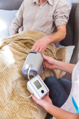 Yakın çekim yaşlı hasta adamın kapalı kolundaki Doktor koyarak tonometer