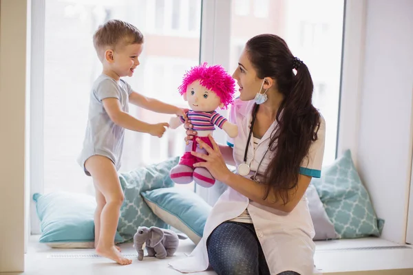 Joven Doctor Sentado Sofá Habitación Cerca Del Niño Divertido Que — Foto de Stock