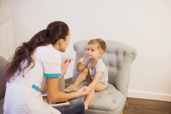 Joven Doctor Sentado Sofá Habitación Hablando Con Niño Lindo Que — Foto de Stock