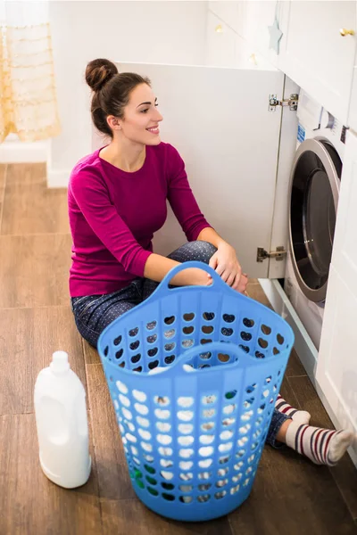 Jonge Lachende Vrouw Zitten Buurt Van Wasmachine Kamer Naar Kijken — Stockfoto