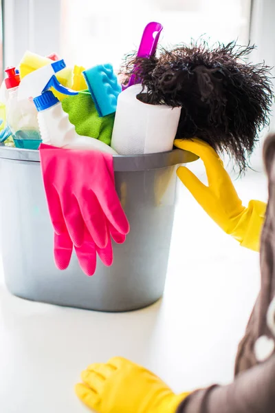 Evde temizlik için eldiven temizlik için sepet şeyler ile yakın duran bir kadın