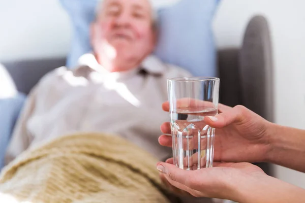 Nahaufnahme Des Wasserglases Der Hand Des Arztes Für Den Alten — Stockfoto