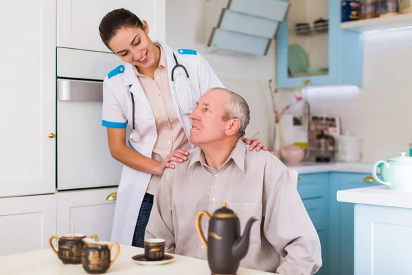 Der Junge Lächelnde Arzt Der Neben Dem Kranken Alten Mann — Stockfoto