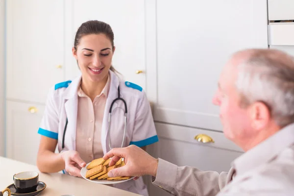 Der Junge Lächelnde Arzt Sitzt Tisch Neben Dem Kranken Alten — Stockfoto