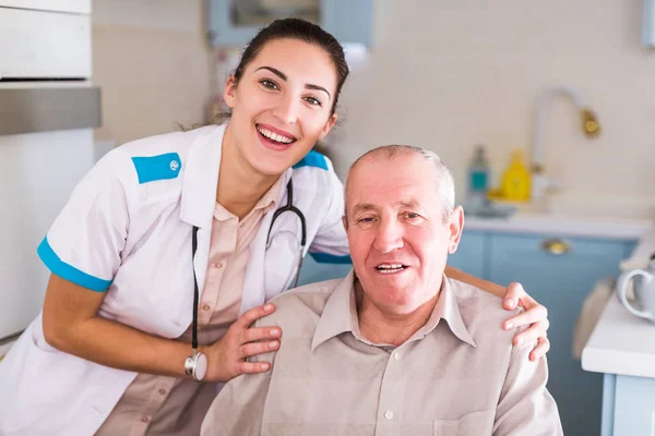 Porträt Der Jungen Lächelnden Krankenschwester Die Neben Dem Alten Kranken — Stockfoto