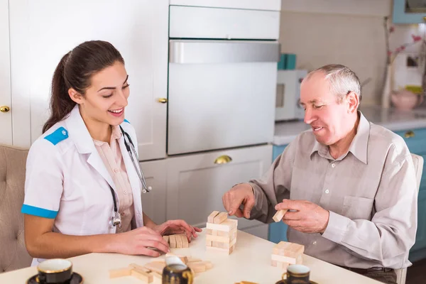 Der Junge Gut Gelaunte Arzt Sitzt Mit Dem Alten Lächelnden — Stockfoto