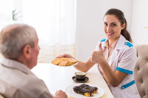 Der Junge Gut Gelaunte Arzt Sitzt Mit Dem Alten Mann — Stockfoto