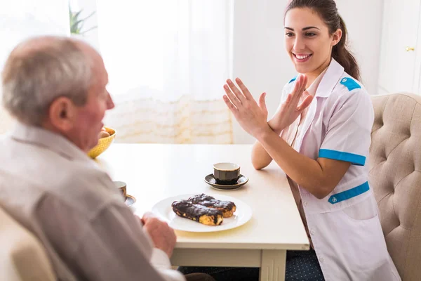 Der Junge Gut Gelaunte Arzt Sitzt Mit Dem Alten Mann — Stockfoto