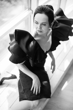 Siyah esmer Bayan büyüleyici genç görünümlü ve kapalı katta oturan bir kenara elbise