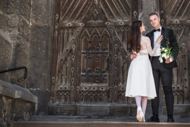 Bir kucaklama yakınındaki eski yapı ayakta romantik genç şık yeni evliler