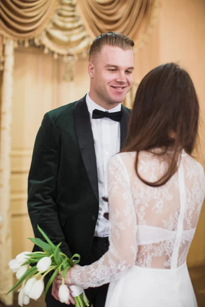 結婚式の日に顔を屋内に立っている若い美しいカップルの肖像画 — ストック写真