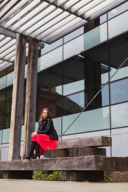 Açık havada ahşap kurullarında oturan genç zarif kadın