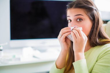 Genç hasta kadın görünümünü ofiste oturan ve burun silmekten yan