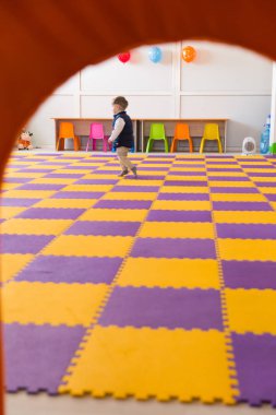 Oyun odasında çalışan mutlu küçük oğlan yan görünüm