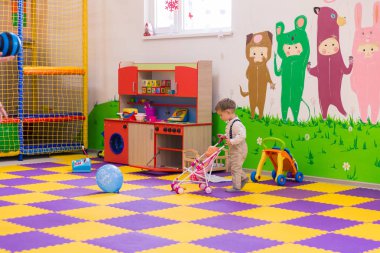 Bir bebek oyun odası ile oynarken küçük çocuk