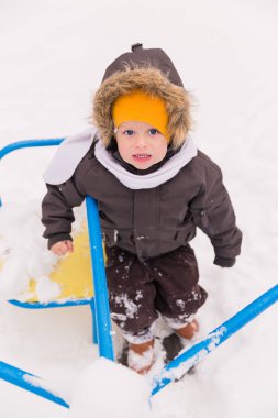 Bahçede bir salıncak üzerinde oturan sevimli küçük çocuk