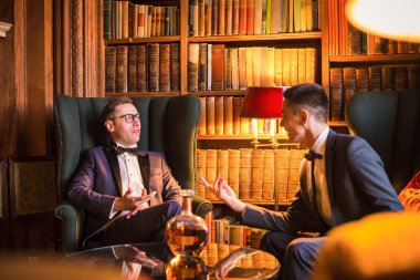 Restoranda oturan ve konuşurken gülümseyen genç şık erkek