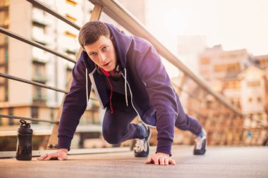 Genç yakışıklı sportif adam açık havada şınav