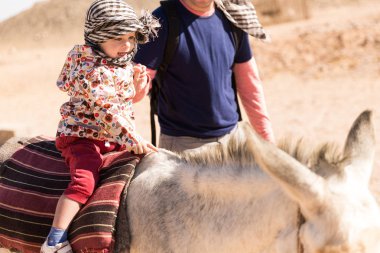 Bir at ve babası onları çölde önde oturan sevimli küçük çocuk
