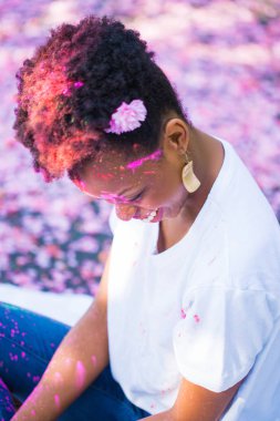 Yüzündeki boya ile açık oturan genç gülümseyen kadın