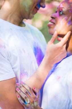 Yakın çekim kucaklama açık havada duran yüzlerinde boyalar aşık genç çift