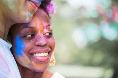 Yakın çekim kucaklama açık havada duran yüzlerinde boyalar aşık genç çift