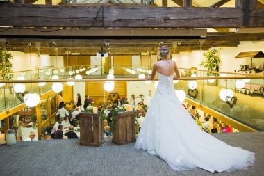 Arkadan görünüşü genç zarif gelin kim Restoran ikinci katlı üzerinde duran ve aşağı bakıyor