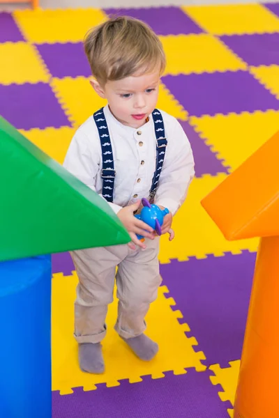 Милый Маленький Мальчик Стоящий Игровой Комнате Держащий Игрушку Руках — стоковое фото