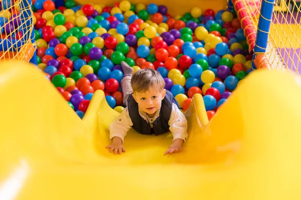Happy Cute Little Boy Playing Game Room Descends Children Slide — стоковое фото