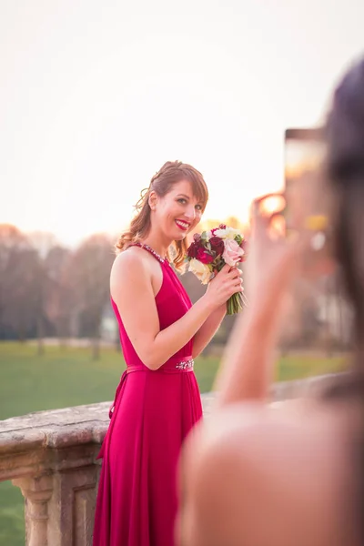 彼女を撮影誰かの手と屋外と花束を立って幸せな若い美しい女 — ストック写真