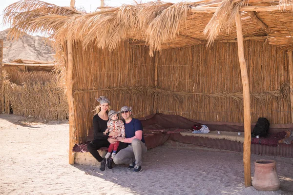 Молодая Счастливая Семья Сидит Скамейке Соломенным Покрывалом Пустыне — стоковое фото