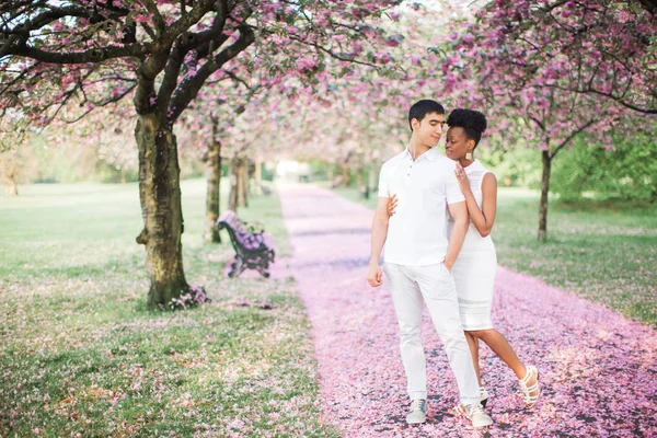 公園に花びらで道路の上に立って目を閉じて若い幸せなロマンチックなカップル — ストック写真