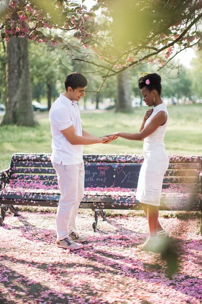 サイドビューの若いカップルの愛パークと男の指に結婚指輪と女性の手を握って それを見て立っている人 — ストック写真