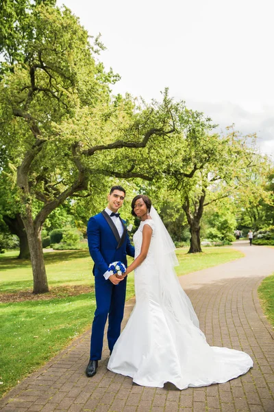 若い幸せな美しい新婚公園に立って 手を繋いでいます — ストック写真