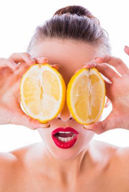 Beyaz arka plan üzerinde gözleri gizleyen elinde iki yarım limon yakın çekim sürpriz olan kadın çıplak omuz tutar