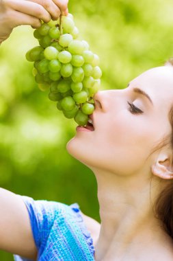 Açık havada üzüm ısırıkları büyüleyici kadın yan görünüm
