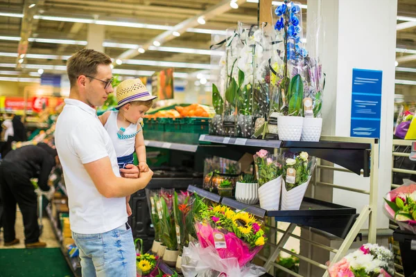 お店に立っている彼の幼い息子を持つ父と植木鉢を見て — ストック写真