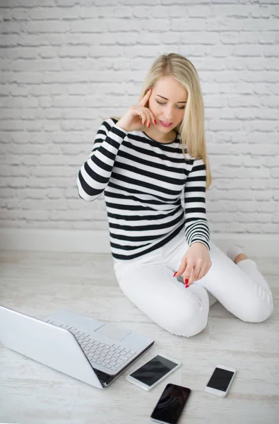 Wesoły Blond Kobieta Siedzi Podłodze Trzech Telefonów Laptopów Patrzy Gadżety — Zdjęcie stockowe