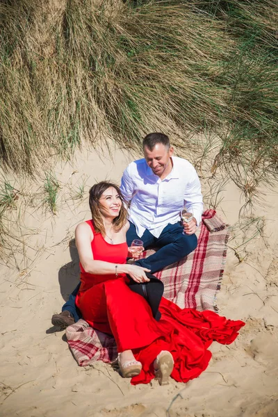 Glückliches Romantisches Lächelndes Paar Sitzt Auf Sand Und Hält Gläser — Stockfoto