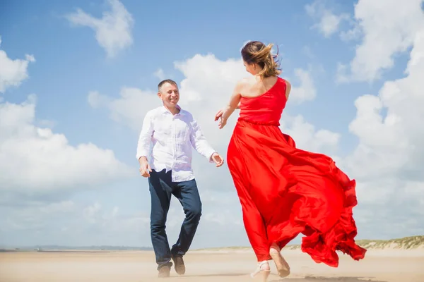 Ευτυχισμένη Σύζυγος Πηγαίνει Προς Σύζυγό Του Στο Κόκκινο Στην Ακτή — Φωτογραφία Αρχείου